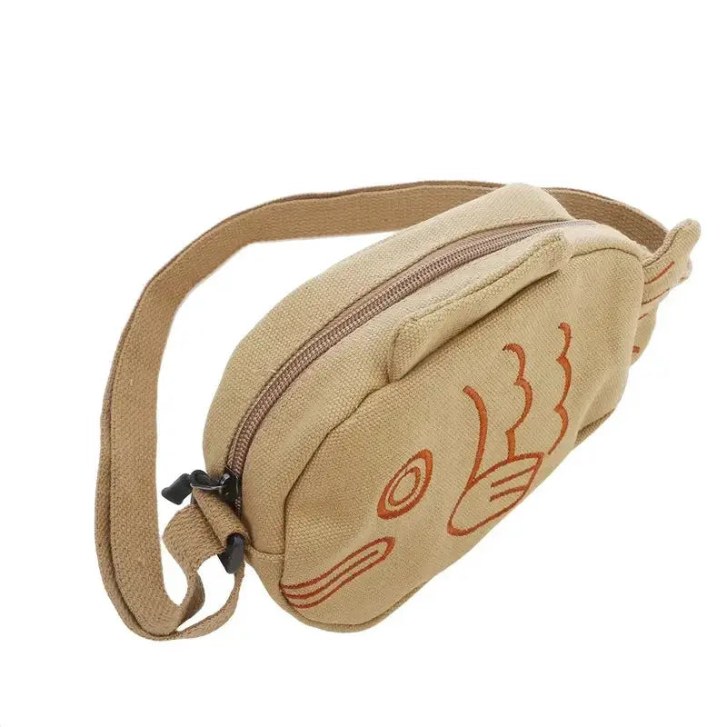 Fish-shaped canvas messenger bag in beige with orange embroidery, zippered top, adjustable strap