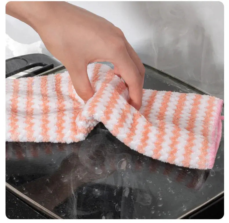 Microfiber cleaning cloth, pink and white striped, high-absorbent kitchen dishcloth being wiped on a stove.