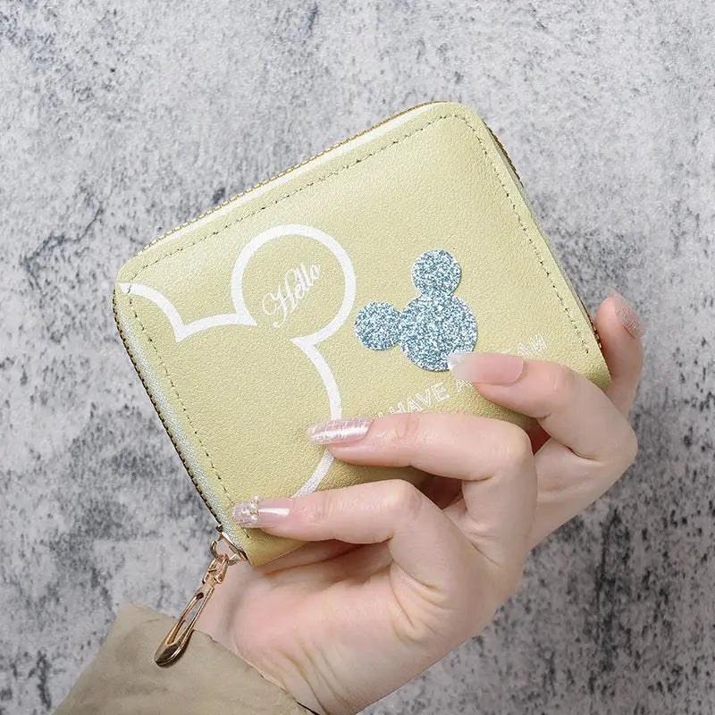 Mini yellow zipper coin purse with white graphic outline and blue glitter Mickey silhouette