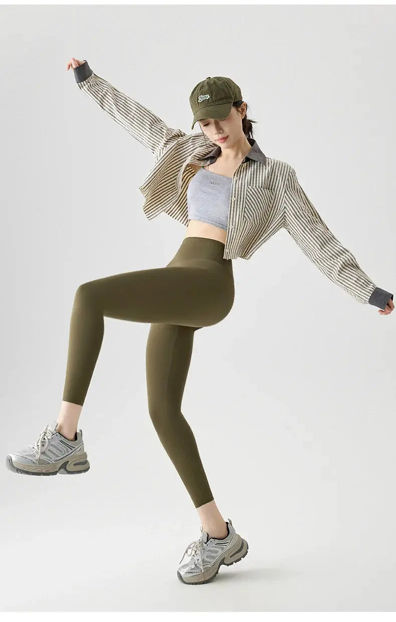 Simples Market BIVIGAOS olive-green seamless sharkskin leggings worn by a model with a striped cardigan and cap