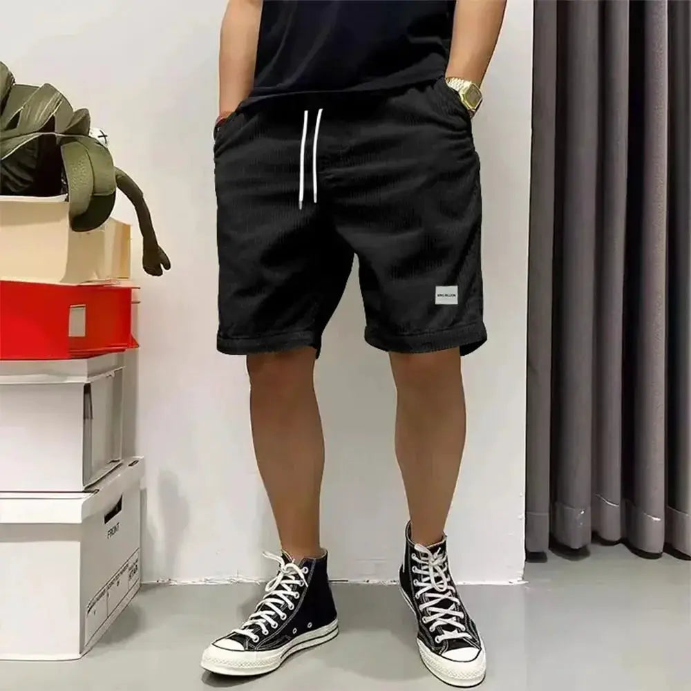 Men's black corduroy shorts with white drawstring, baggy elastic waist, mid-thigh length, Simples Market brand.