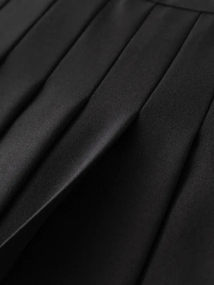 Blazer fabric close-up in black with sharp pleats and smooth texture