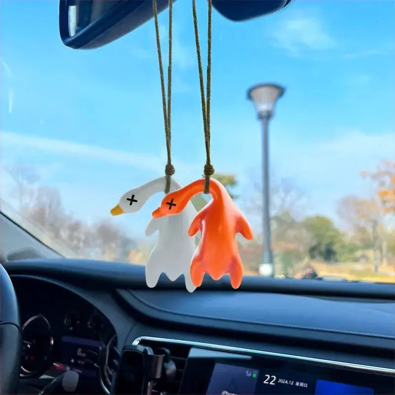 Color-changing roast duck pendants, white and orange car keychain charms (2) hanging from a rearview mirror.