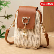 Mini crossbody phone bag from Simples Market; tan leather flap, woven straw body, gold hardware