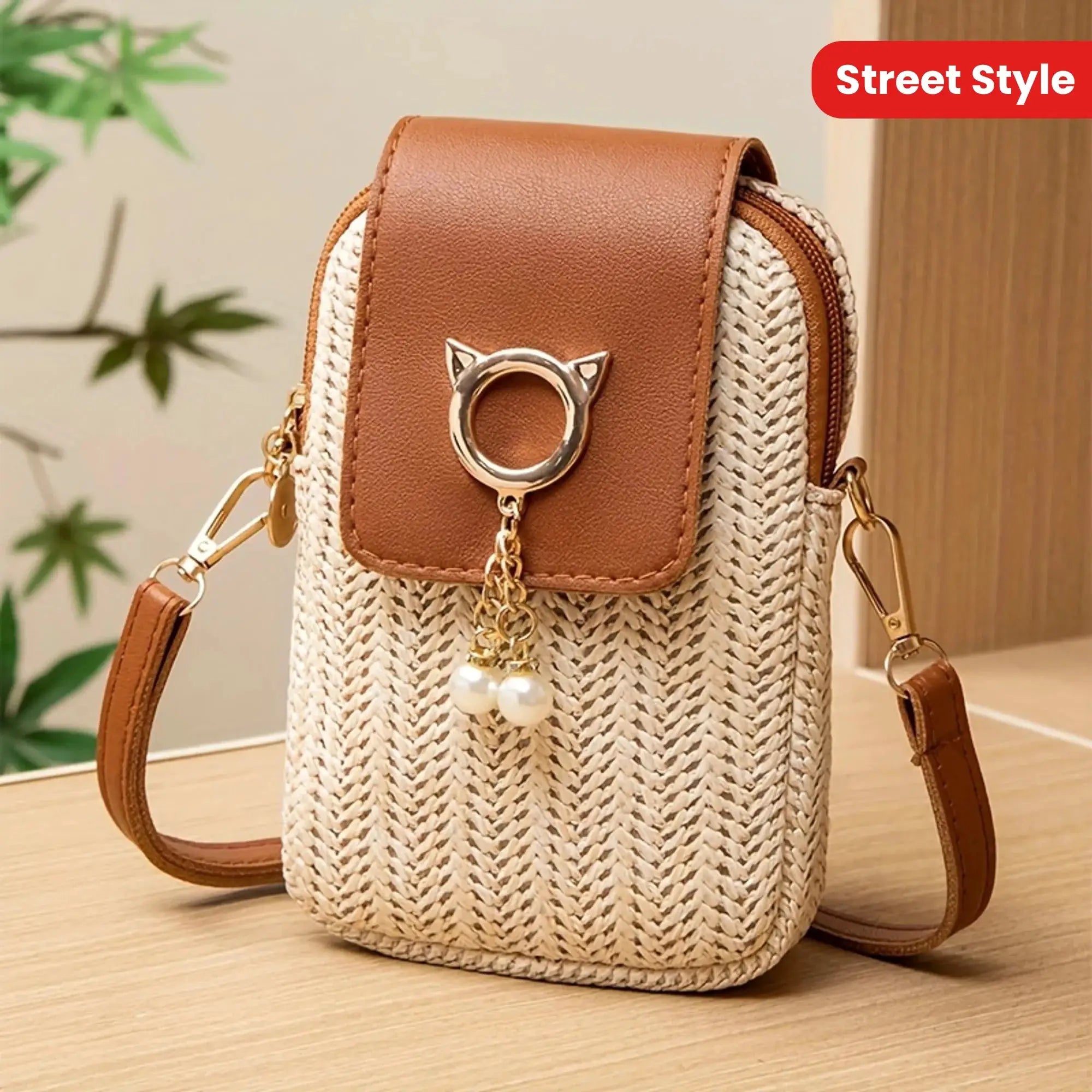 Mini crossbody phone bag from Simples Market; tan leather flap, woven straw body, gold hardware