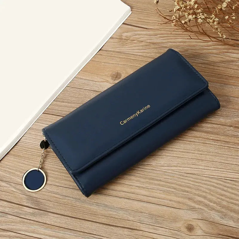 Navy PU leather long wallet with gold logo text and attached round navy key-ring charm.