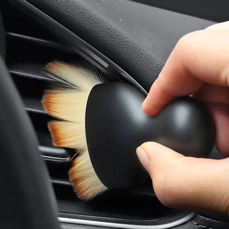 Car interior cleaning brush with thick soft tan fur and black handle for dusting air vents.