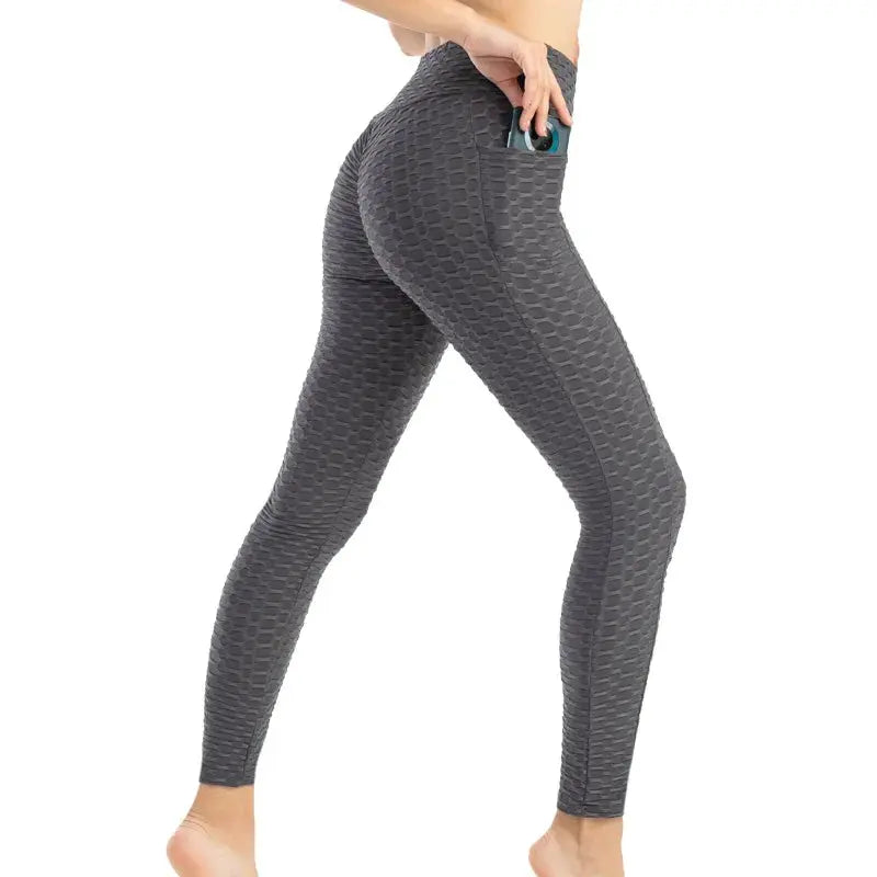Women's grey bubble-textured pocket leggings with high waist for gym workouts.