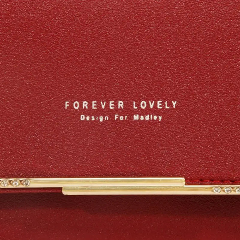 Simples Market women's red leather wallet with gold bar clasp and crystal accents