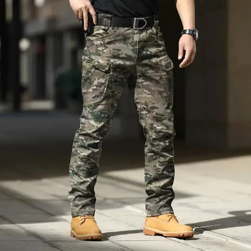 Men's Simples Market softshell tactical cargo pants in camo; stretchy fabric, multiple pockets, belt, button fly
