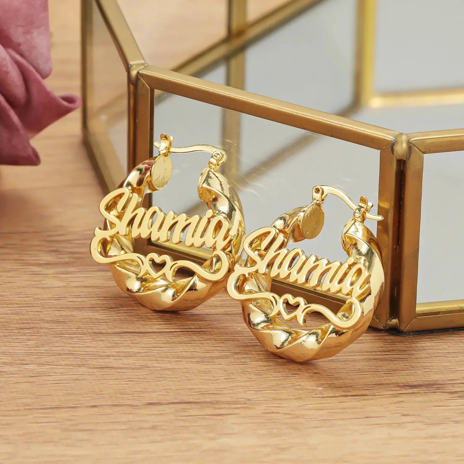 Two gold-tone personalized name hoop earrings with twist detail