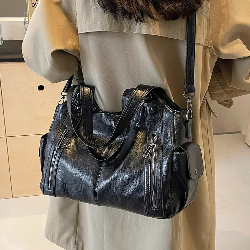 Black PU leather shoulder bag with soft interior compartments and front zip pockets, detachable crossbody strap