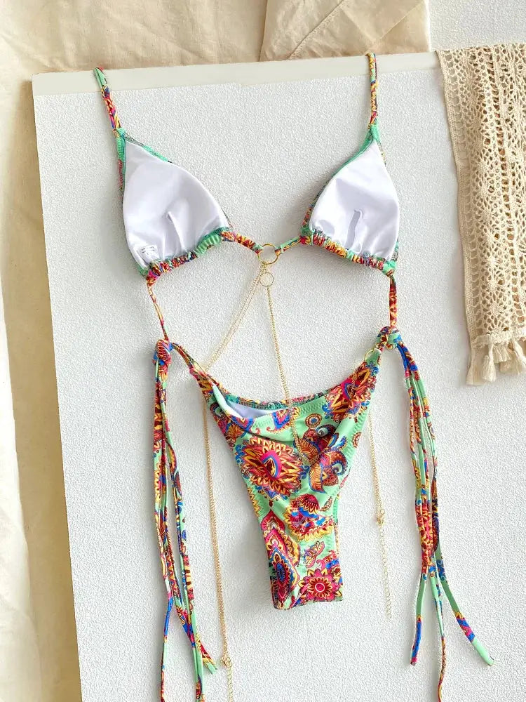 Triangle-chain bikini set with white cups, vibrant multicolor printed thong bottom, and gold chain accents.