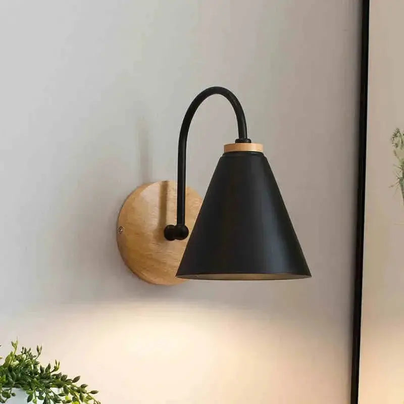 Nordic wall sconce light by Simples Market; black curved arm, black cone shade, wooden mounting plaque