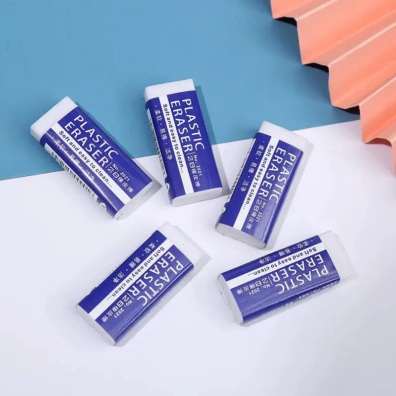 2B plastic erasers in blue and white wrappers, six pieces scattered on a white and blue background