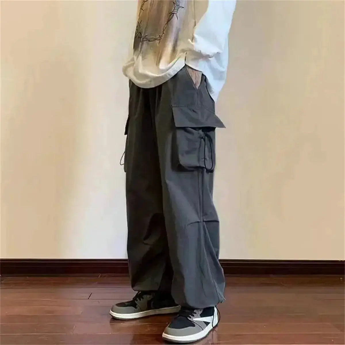 Cargo pants with elastic waist, dark gray color and multiple pockets, loose baggy fit