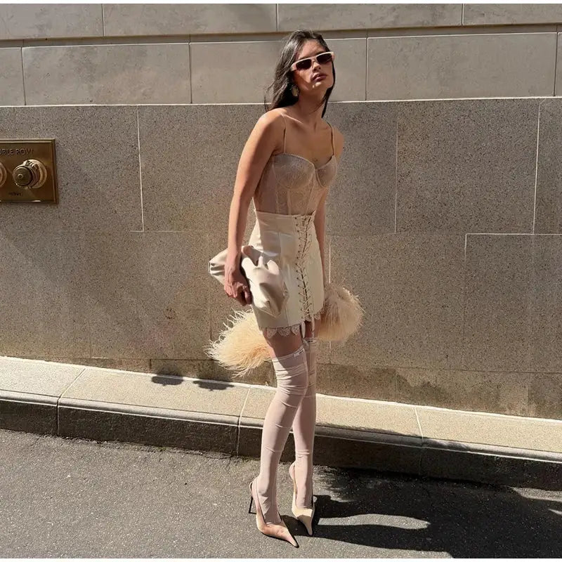 Beige lace-up mini skirt for women, high-waisted, styled with nude stockings and pointed heels