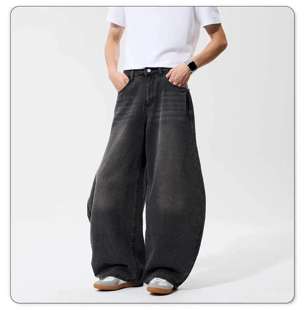 Men's baggy wide-leg denim jeans in dark grey/black wash, retro street style.