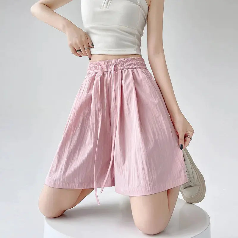 Women’s pink high-waist shorts with elastic waistband and drawstring, casual loose-fit beach shorts soft cotton fabric.