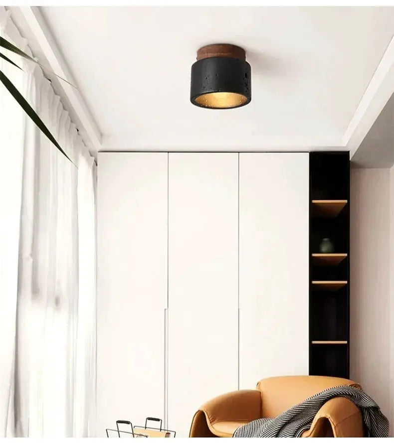 Wabi-sabi black ceiling lamp with wooden base and gold interior in a modern white cabinet room