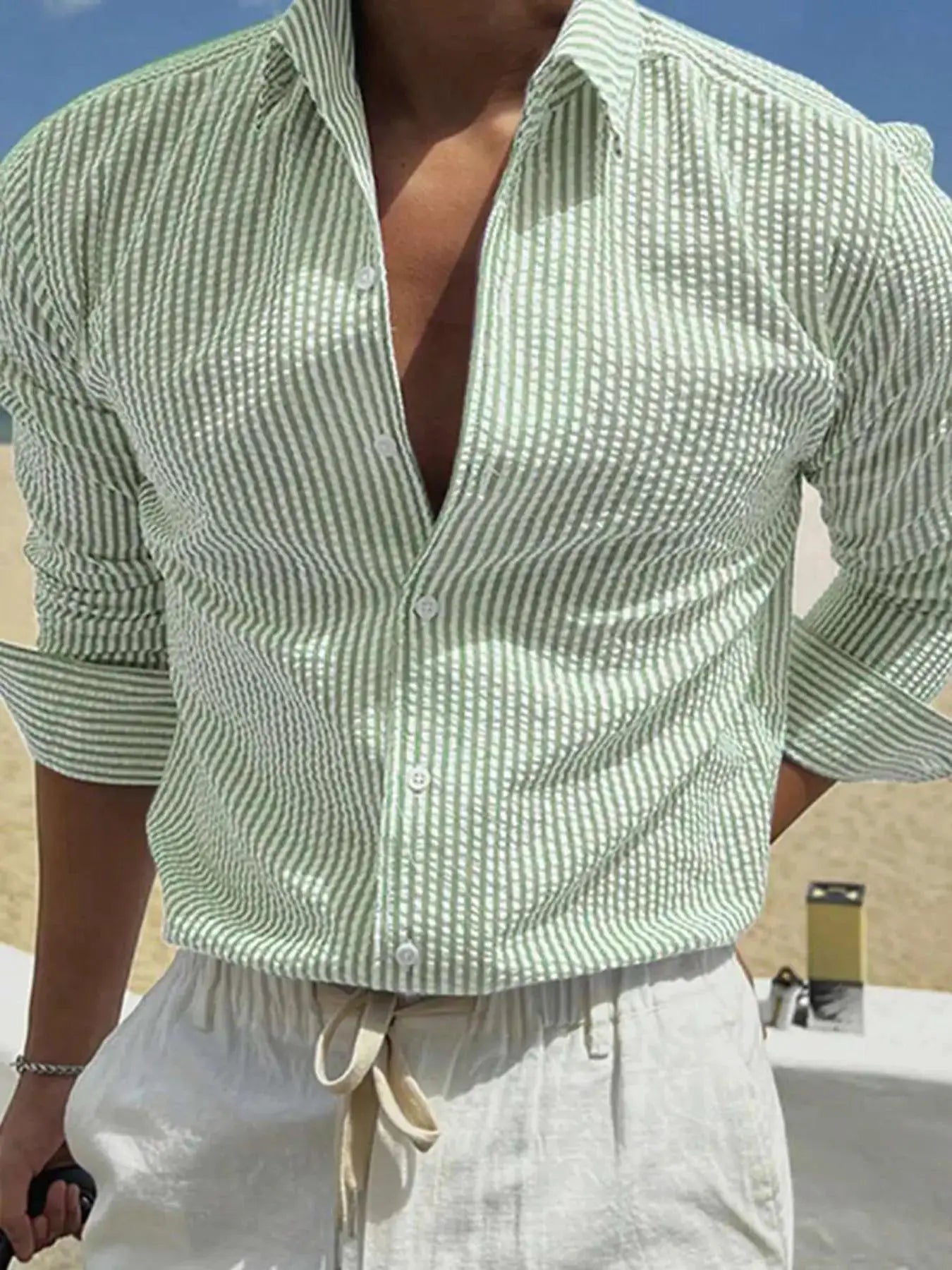 Men's green and white striped button-down shirt with rolled sleeves, loose casual fit.