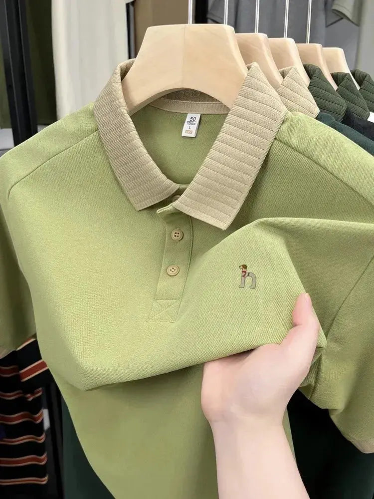 Men's short-sleeve polo shirt in light olive green with beige ribbed collar and small embroidered dog.