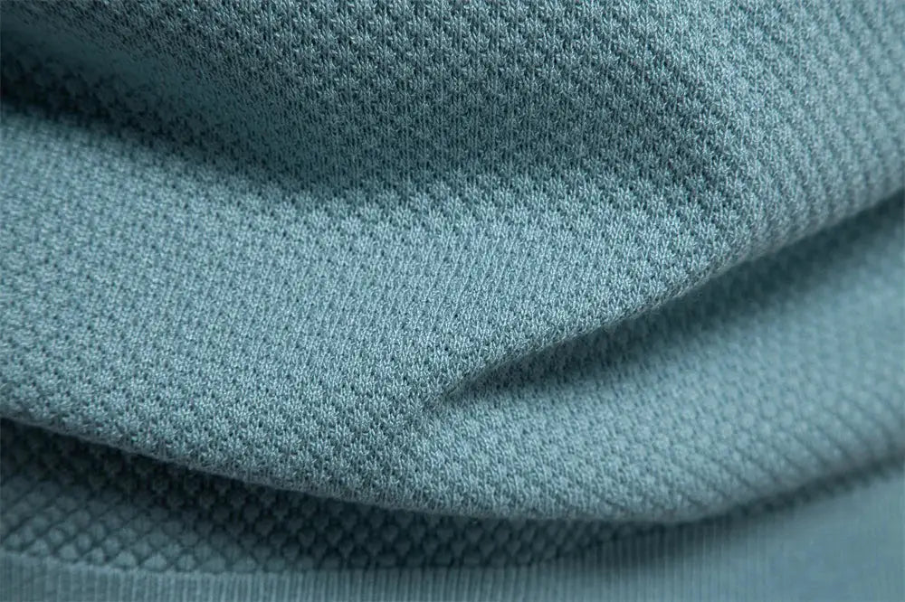 Men's golf polo shirt in teal, solid color, breathable knit fabric close-up