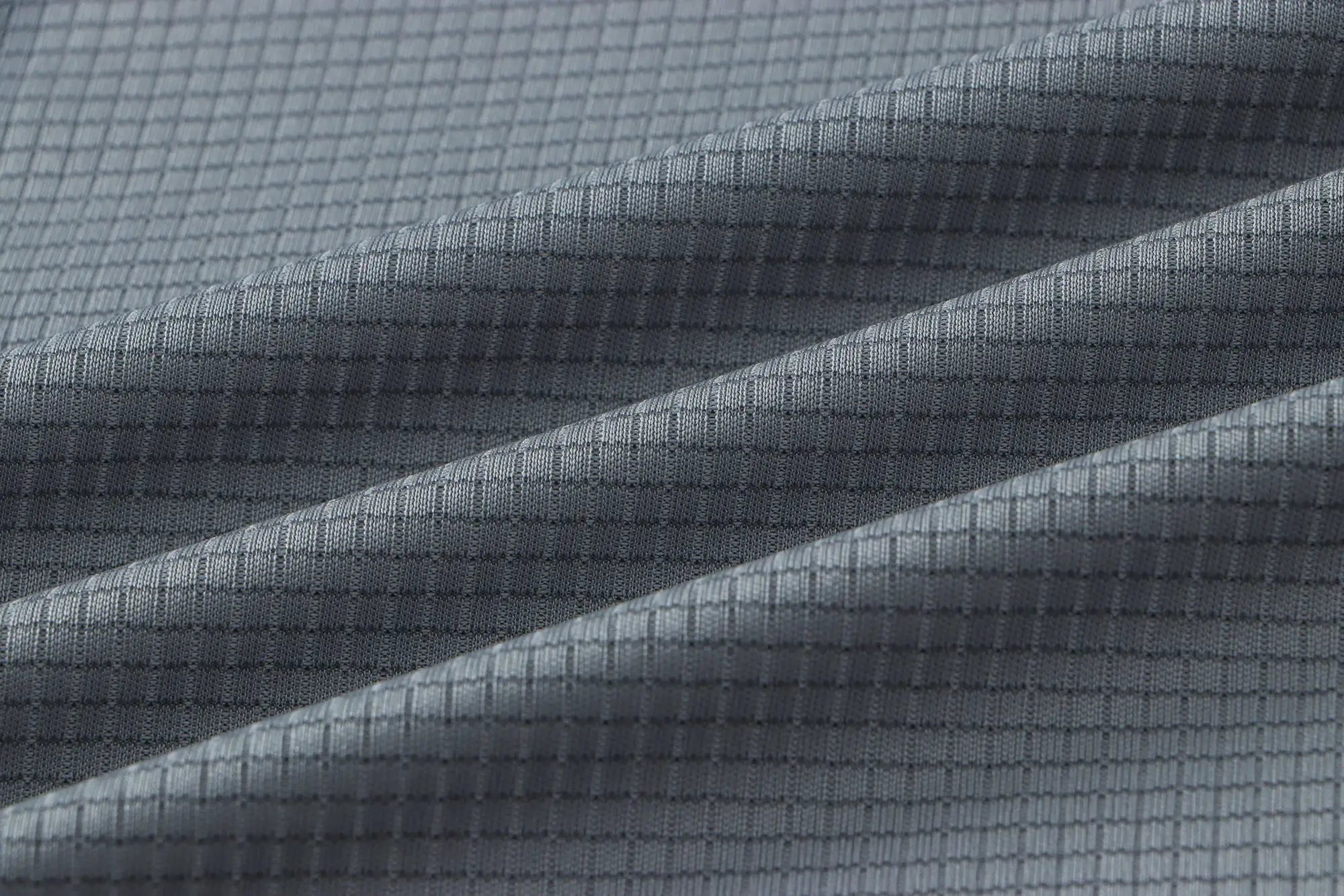 Men's quick-dry gym T-shirt fabric texture in gray with a grid-weave pattern.