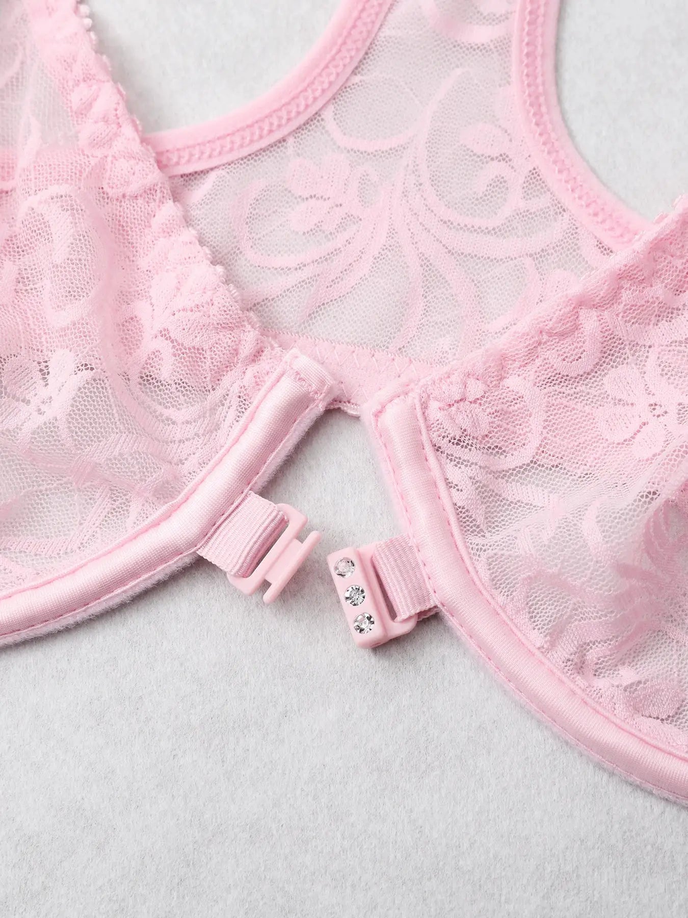 Pink lace front-closure bra with floral mesh pattern and rhinestone clasp