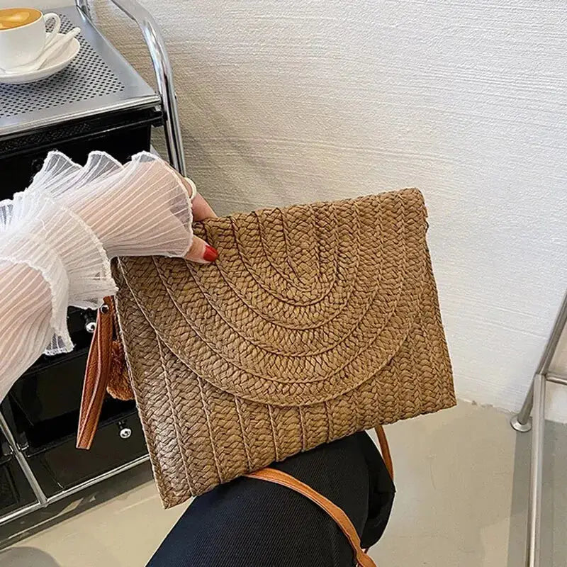 Handmade straw crossbody bag with envelope flap in natural brown woven texture.