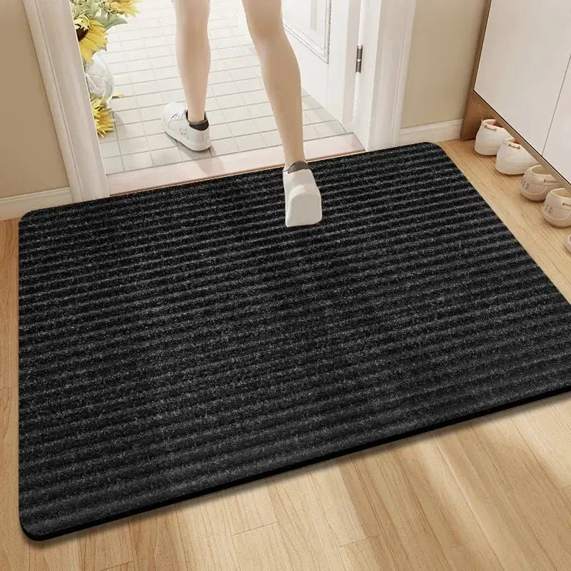 Entrance mat, black ribbed, anti-slip and water-absorbent for indoor and outdoor use.