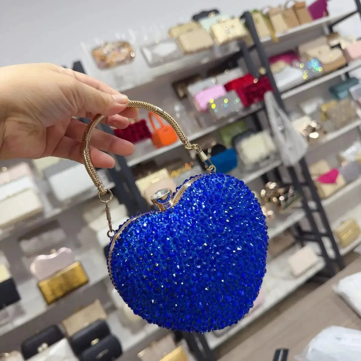 Heart-shaped blue crystal clutch purse with a gold-tone handle for evening wear