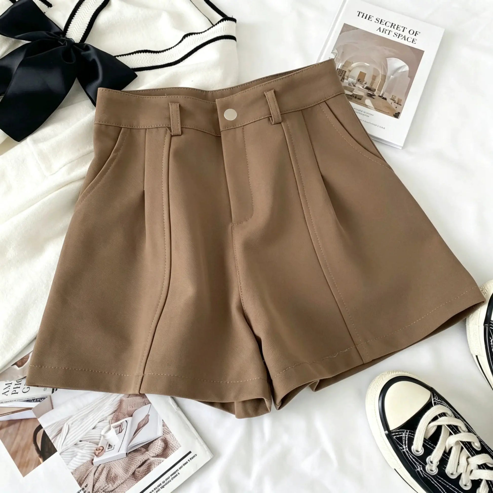 Tan women's high-waisted A-line shorts with belt loops and front pleats.