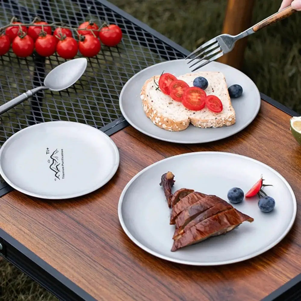 Titanium camping plates by Simples Market; frosted round, lightweight reusable tableware, 3 plates on an outdoor table