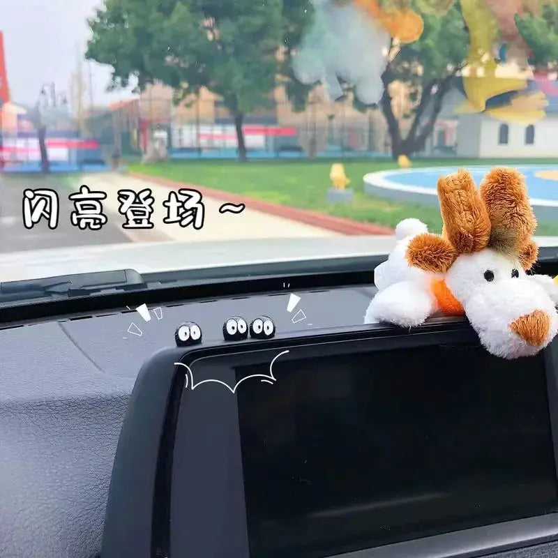 2-piece plush elf car ornaments on the dashboard near the center console, white with brown ears