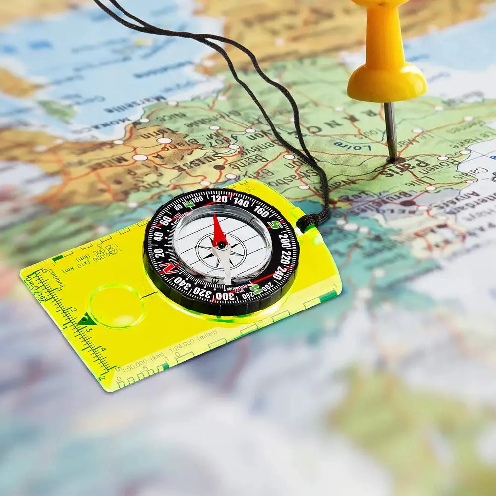 Simples Market waterproof compass for outdoor navigation; bright yellow plastic with black dial on map