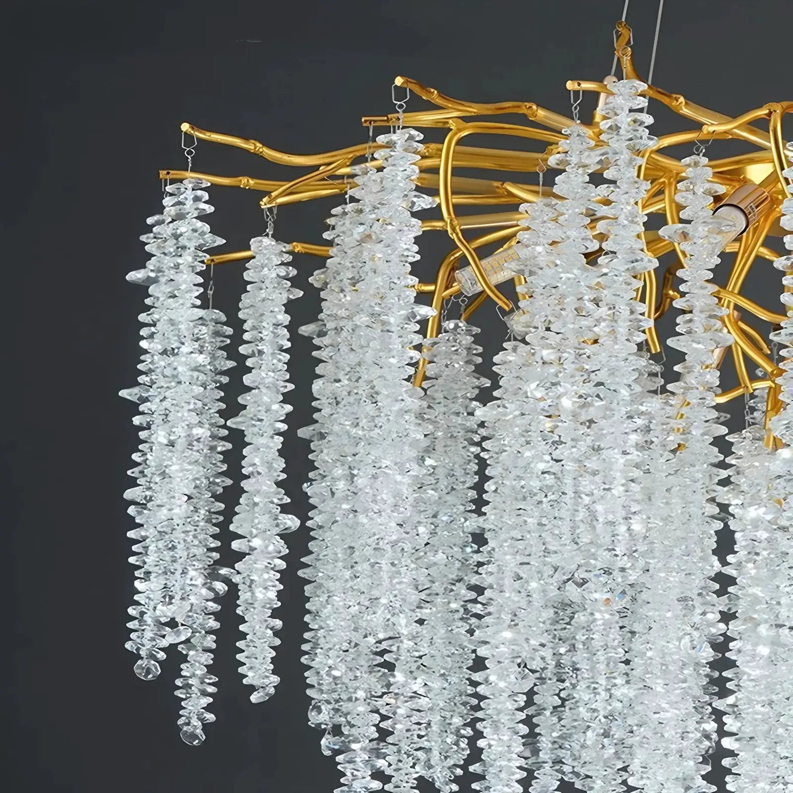 Modern crystal chandelier by Simples Market with gold metal branches and hanging crystal strands.