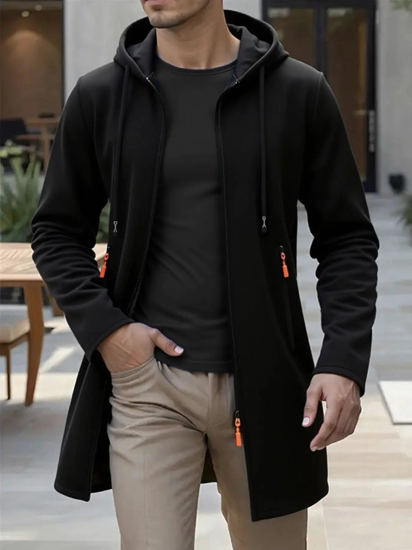 Men's black hooded long jacket with front zipper and orange zipper pulls on pockets