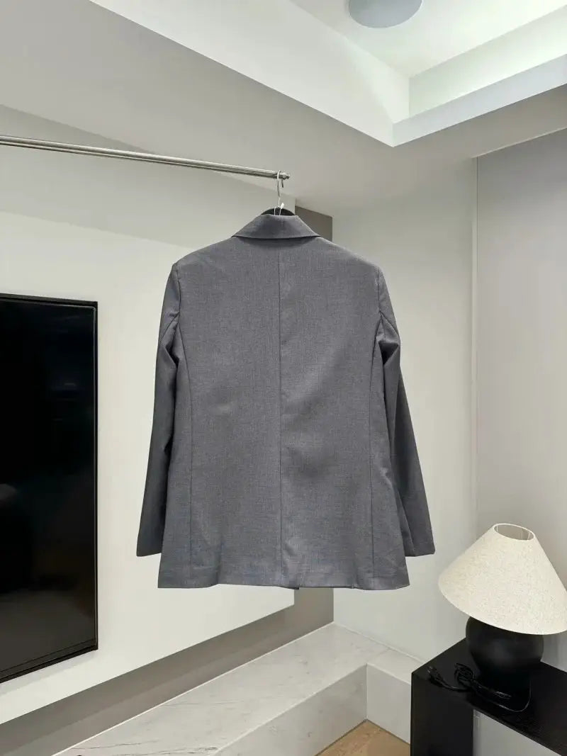 Gray women's shoulder-padded double-breasted blazer on hanger