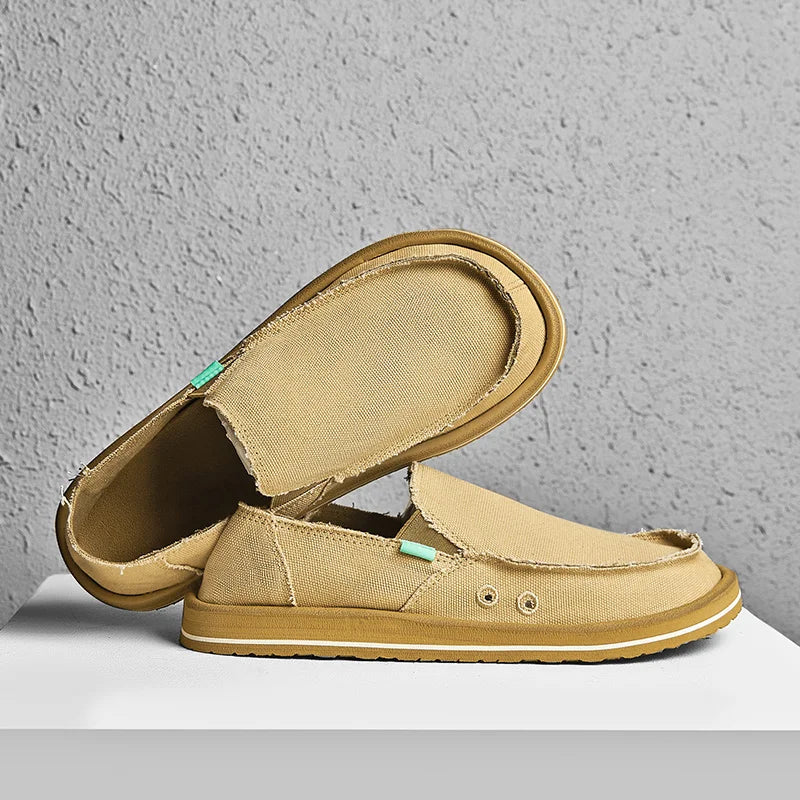 Pair of beige canvas men's loafers; low-top slip-ons with light brown sole, breathable casual driving shoes