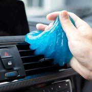NewAuto blue car cleaning gel in hand, used to remove dust from air vents and keyboards