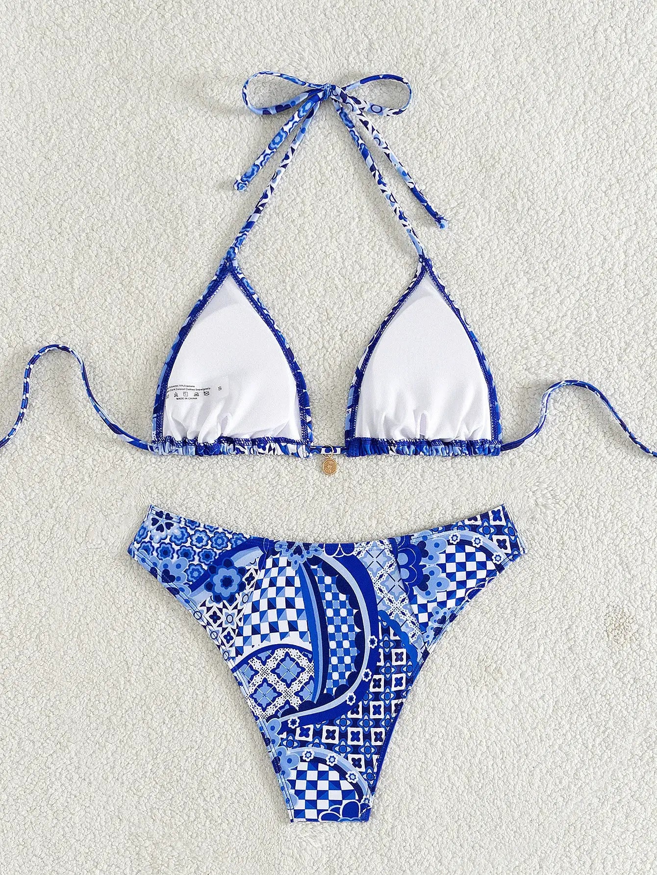 Simples Market two-piece triangle bikini set, blue floral print with white cups and Brazilian-cut bottoms.