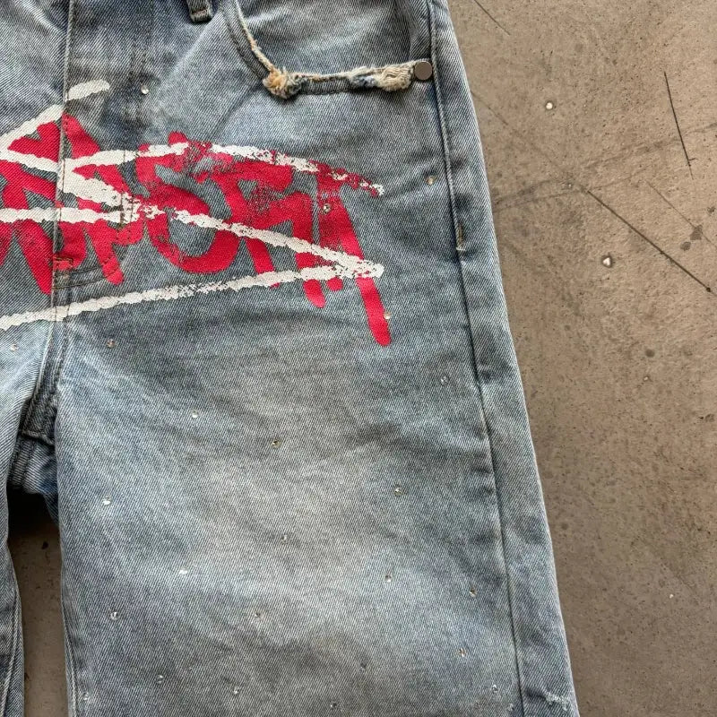 Denim shorts with red graffiti print, rhinestone accents, distressed detailing, unisex baggy fit