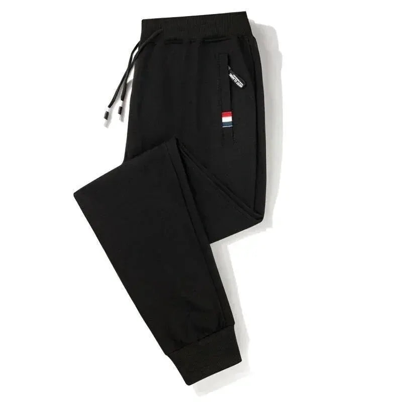 Men's black cotton jogger pants with elastic waist, drawstring, and cuffed ankles.