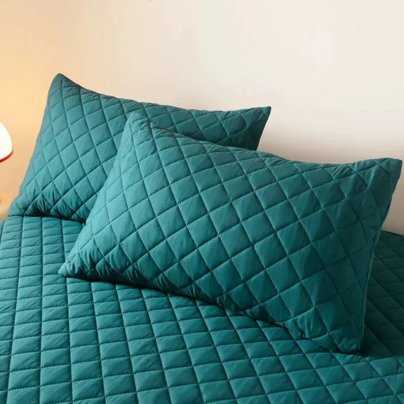 Teal quilted cotton double-deck pillowcases on bed, waterproof and antibacterial.