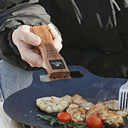 Simples Market outdoor grill pan handle with solid wood anti-scald grip and adjustable clip on blue pan.