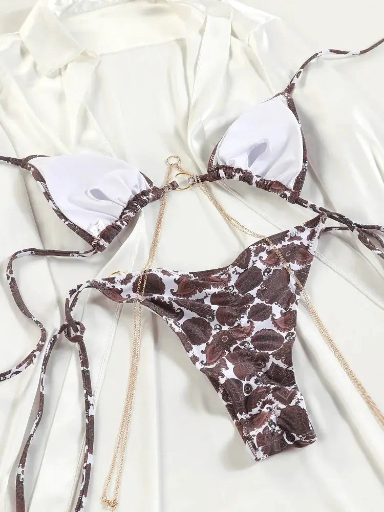 Simples Market triangle chain bikini set with brown floral print, white cups, and gold chain details.