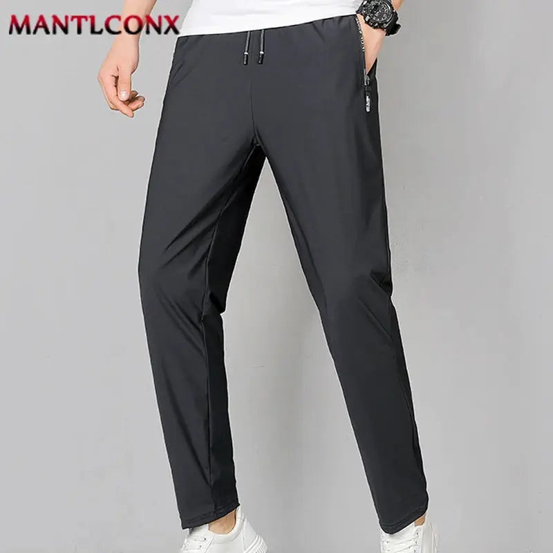 Breathable men's quick-dry black jogger pants with elastic waist and zip pockets; MANTLCONX logo