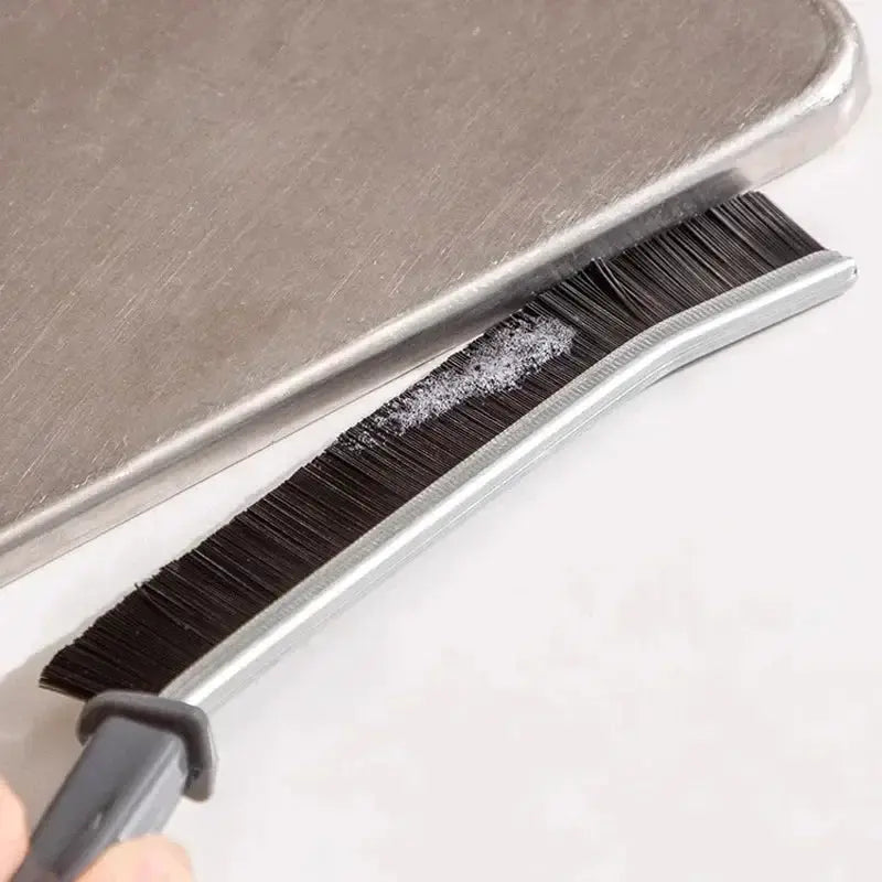 Grout gap cleaning brush with hard black bristles and gray handle for tile joints and shower floors.