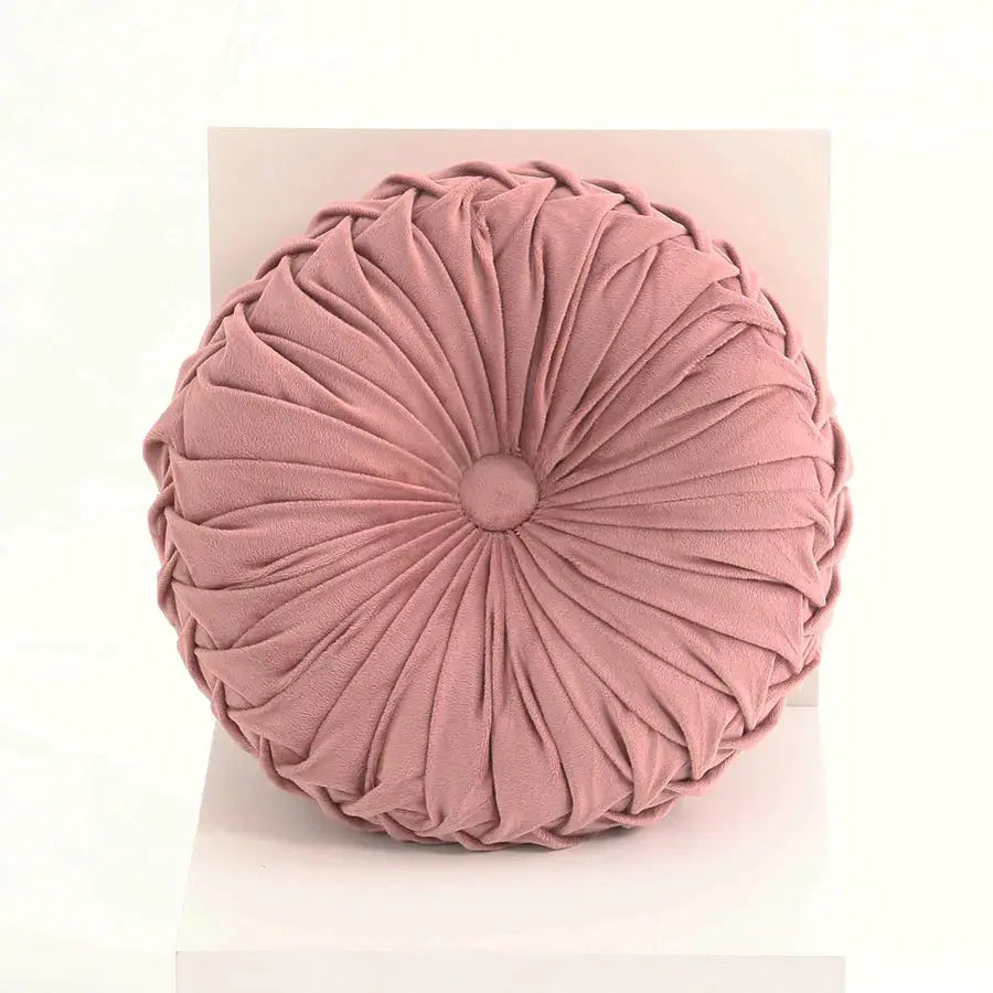 Round pink velvet throw pillow with hand-sewn pleated 3D pumpkin design.